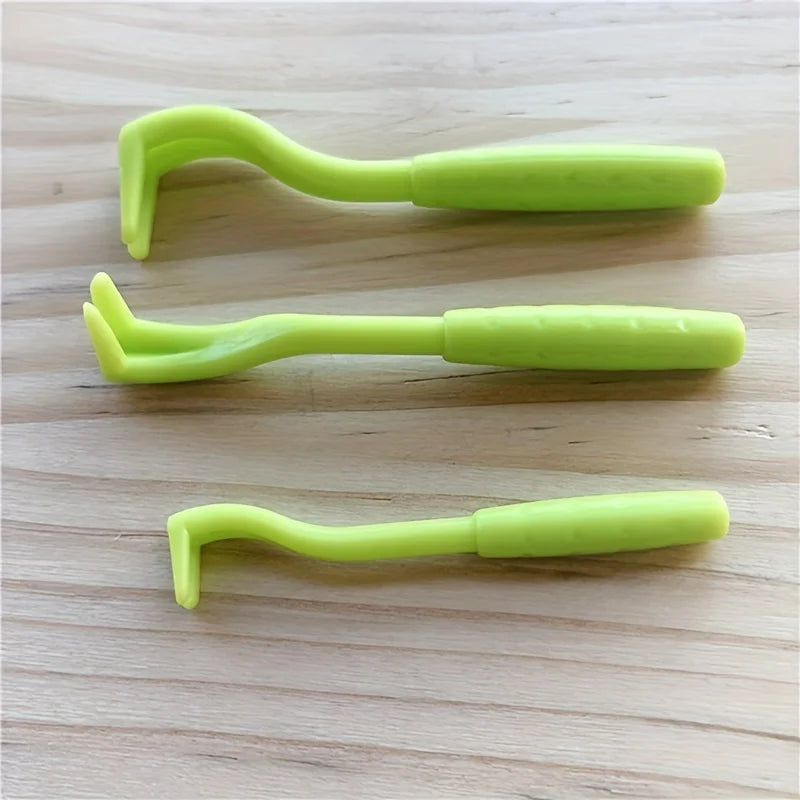 Three green plastic tools on a wooden surface - Close-up of pet flea removal kit for dogs and cats.