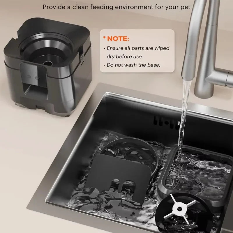 Pet feeding station being rinsed under running water in a sink with a note on cleaning instructions, 2L smart Wi-Fi automatic pet feeder for cats and small dogs.
