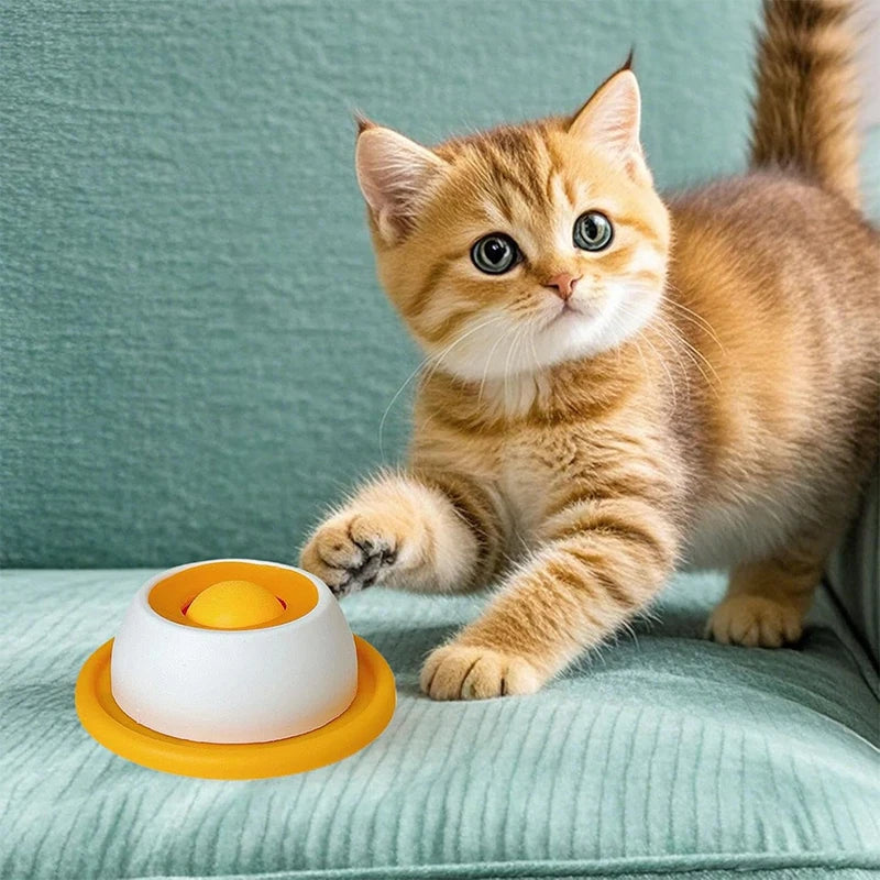 Cat using a yellow interactive licking plate for treats, wet food, and slow feeding.